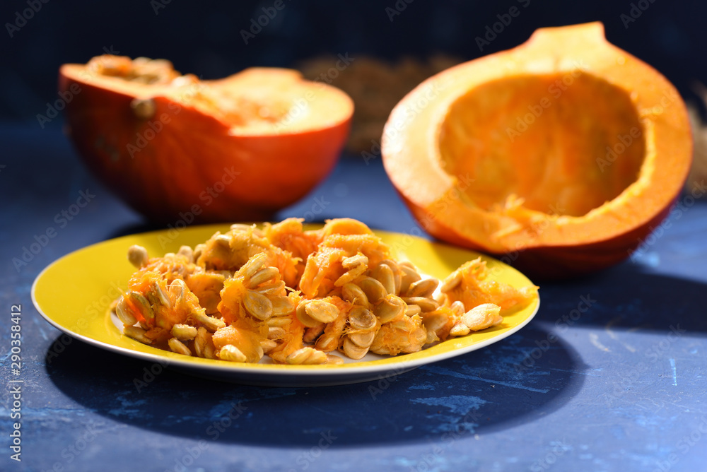 Pumpkin seeds on a plate, blue table Pumpkin seeds on a plate, blue table
