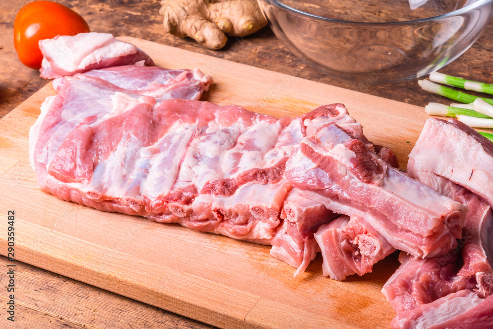 Raw chopped pork ribs on a wooden cutting board