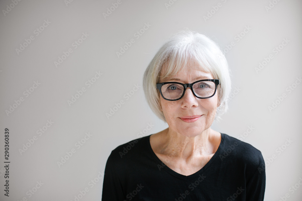 Studio portrait of senior woman on simple grey background Studio portrait of senior woman on simple grey background