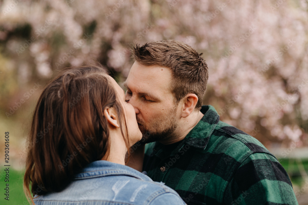 Couple Kissing with Cherry Blossoms in Background Couple Kissing with Cherry Blossoms in Background