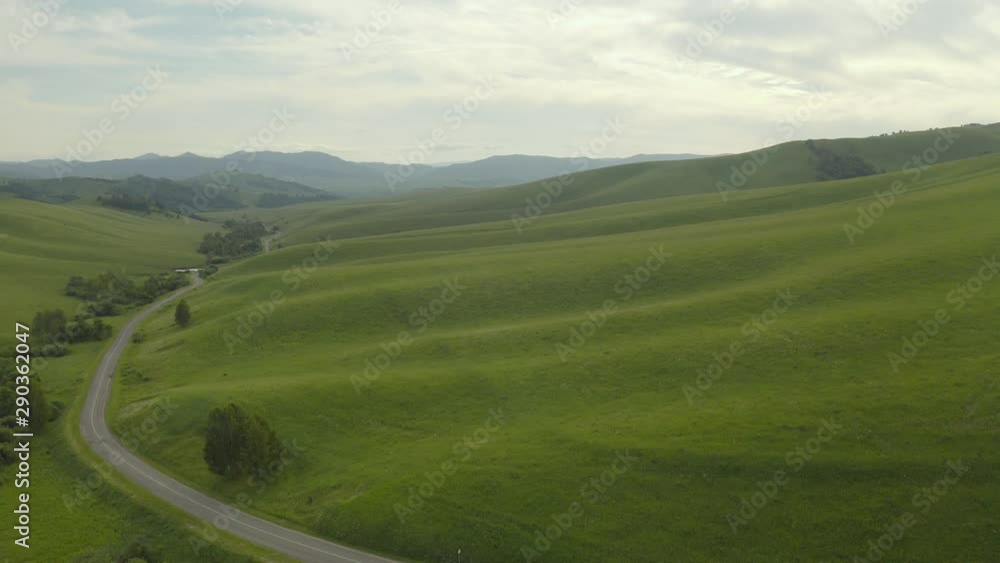 4K resolution, aerial drone at 29 frames per second over mountain in National Park with cloudy skies. Road through the hills. 4K resolution, aerial drone at 29 frames per second over mountain in National Park with cloudy skies. Road through the hills.