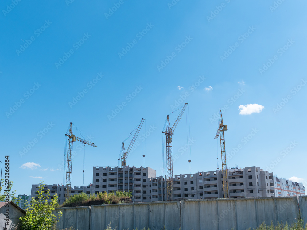 Construction site with many cranes against the sky Construction site with many cranes against the sky