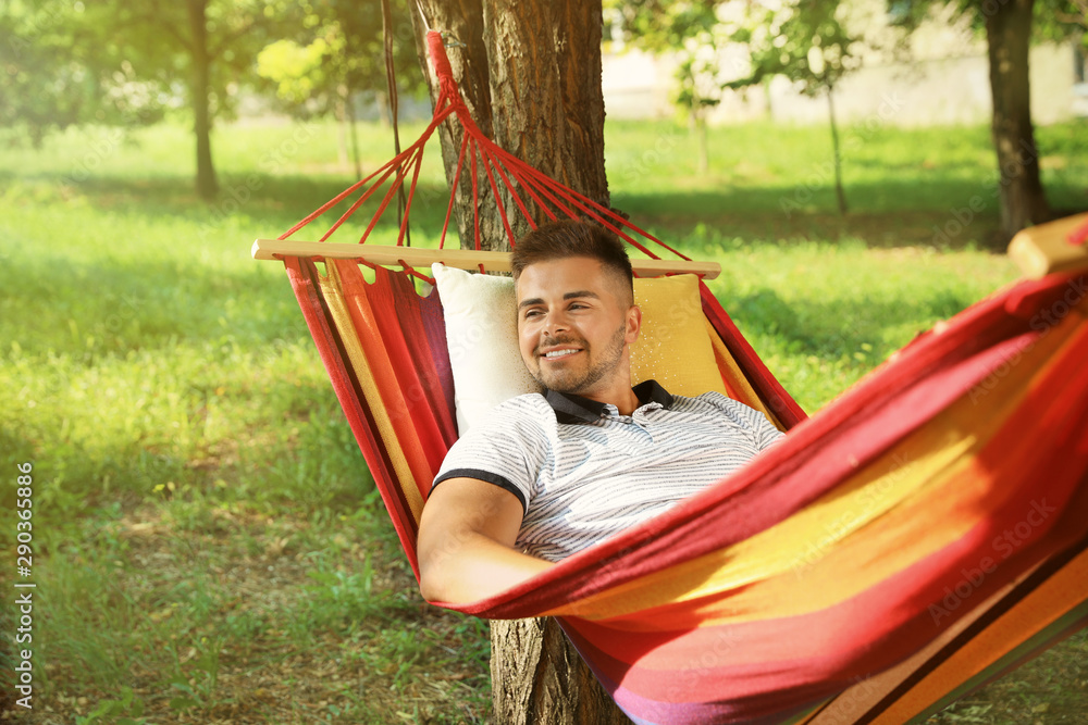 Young man resting in comfortable hammock at green garden Young man resting in comfortable hammock at green garden