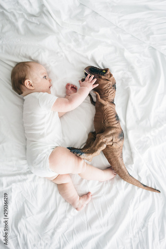 Baby playing with a toy dinosaur photo