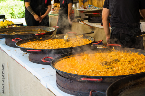 Paella served from paella dishes on a street food festival.