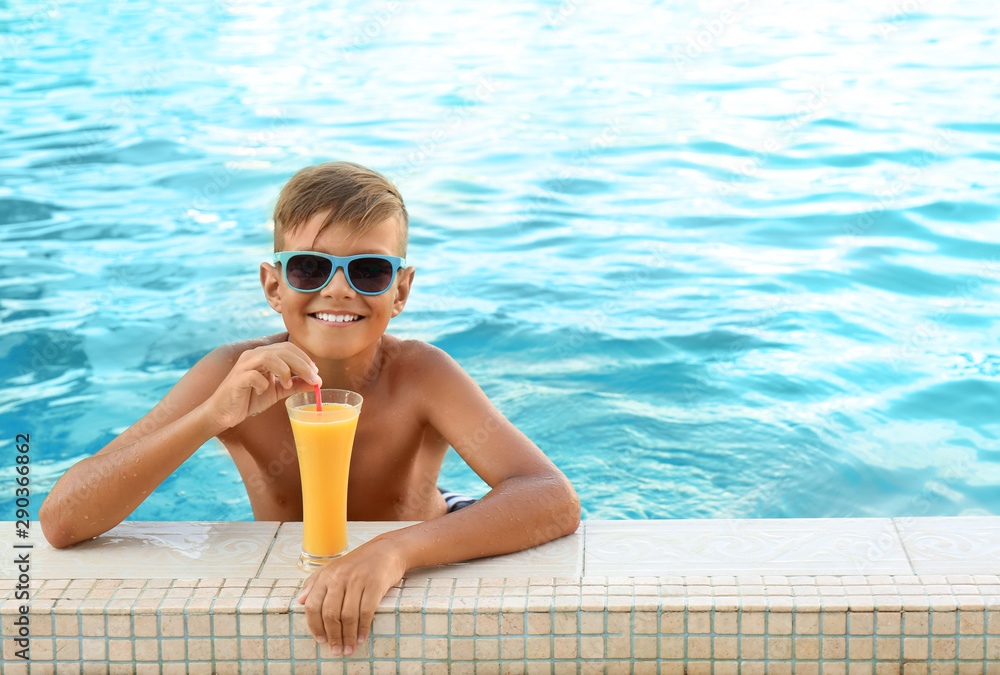 Happy cute boy with drink in swimming pool