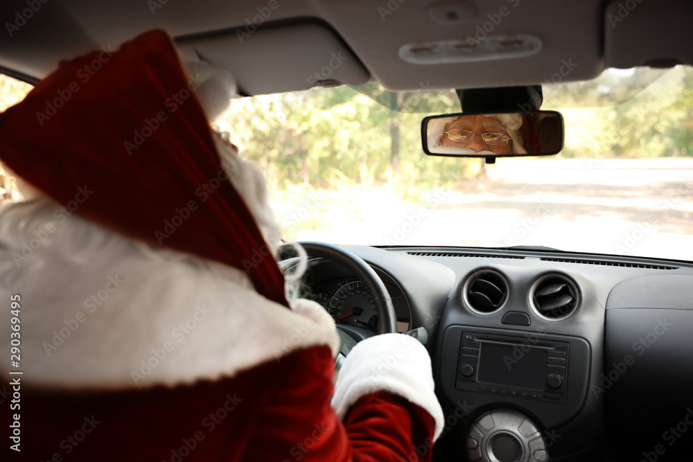 Authentic Santa Claus looking at rear-view mirror of car Authentic Santa Claus looking at rear-view mirror of car