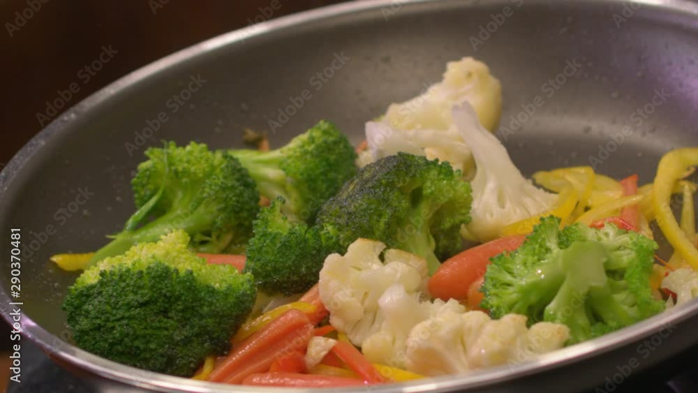 Frying fresh vegetables with Olive Oil. Close shot. Slow motion. 4K