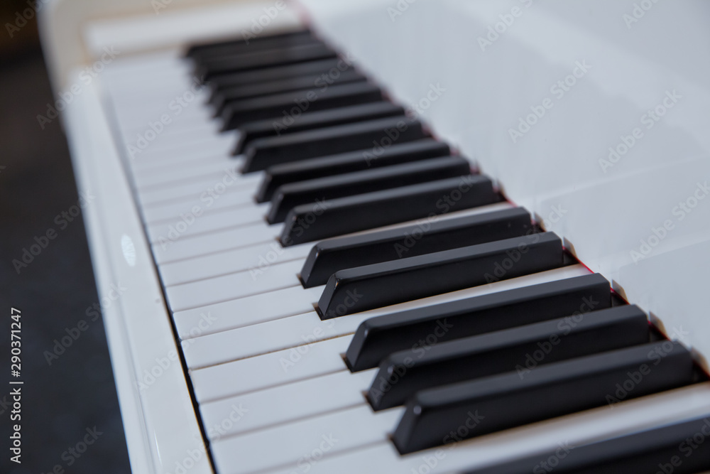 grand piano keyboard with glossy black and white keys as a music background in wide panoramic banner format, selected focus, narrow depth of field grand piano keyboard with glossy black and white keys as a music background in wide panoramic banner format, selected focus, narrow depth of field
