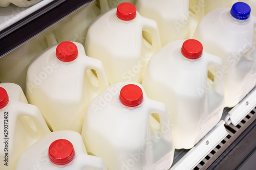 Several gallon jugs of milk at the grocery store