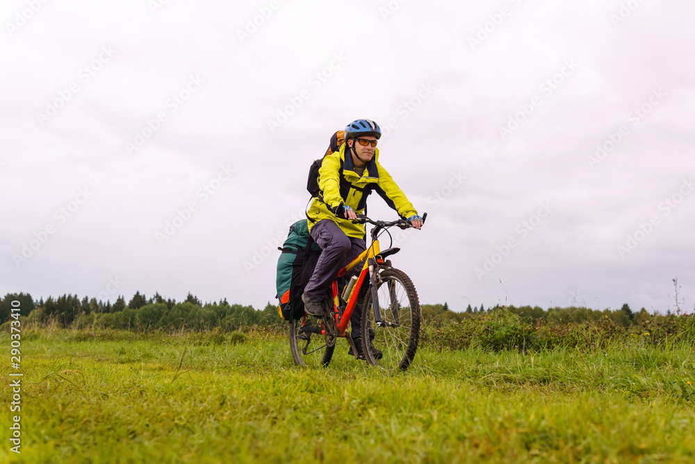 Fototapeta premium cyclist traveler rides through the natural landscape