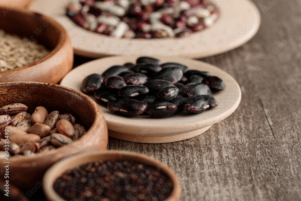brown bowls and plates with black beans and grains on table brown bowls and plates with black beans and grains on table