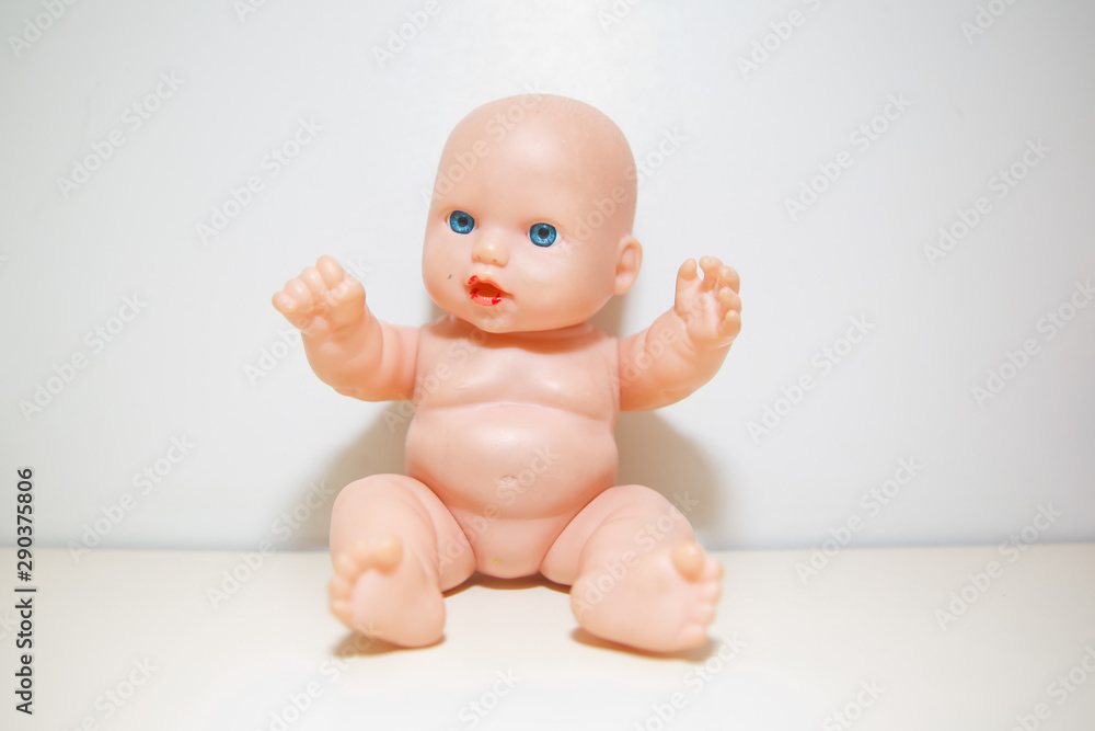 Cute little naked baby doll with blue eyes sitting or walking . Copy space.There is no clothes on the doll . baby doll isolated in white background closeup . Doll white background no clothes . Cute little naked baby doll with blue eyes sitting or walking . Copy space.There is no clothes on the doll . baby doll isolated in white background closeup . Doll white background no clothes .