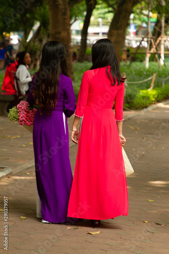 Women wearing ao zai, walking in park, Hanoi, Vietnam