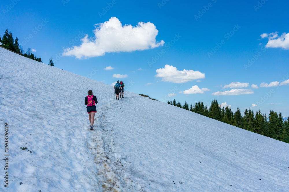 People hiking through snow on a mountain