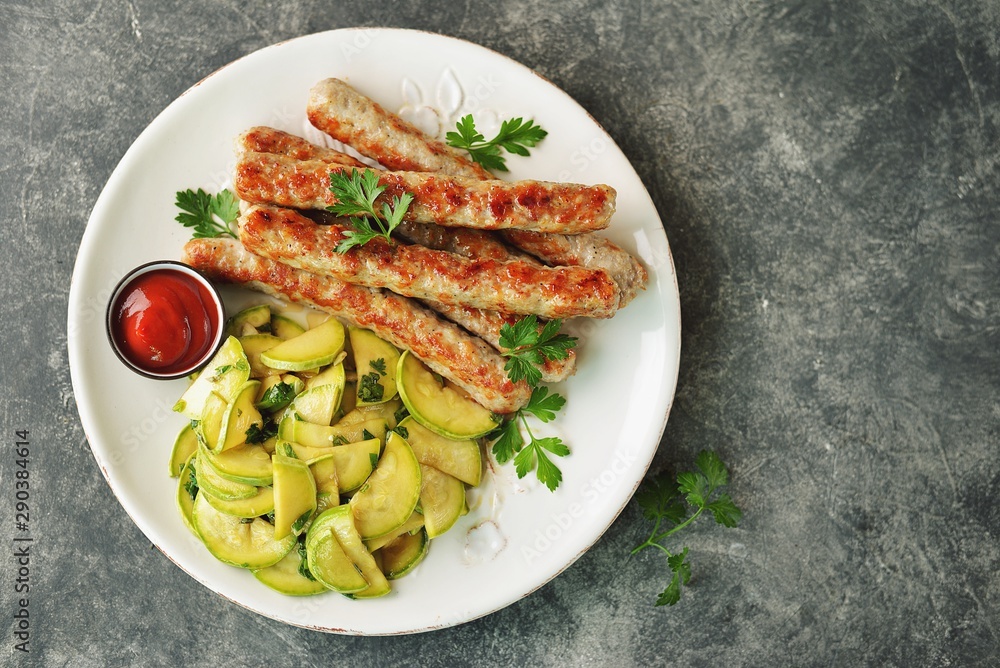 Grilled chicken sausages with zucchini salad in olive oil, soy sauce, wine vinegar, garlic and cilantro. Top view. Grilled chicken sausages with zucchini salad in olive oil, soy sauce, wine vinegar, garlic and cilantro. Top view.