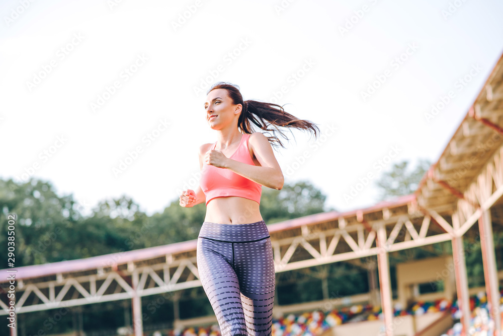 beautiful girl sporting appearance running. Girl running on sunset background