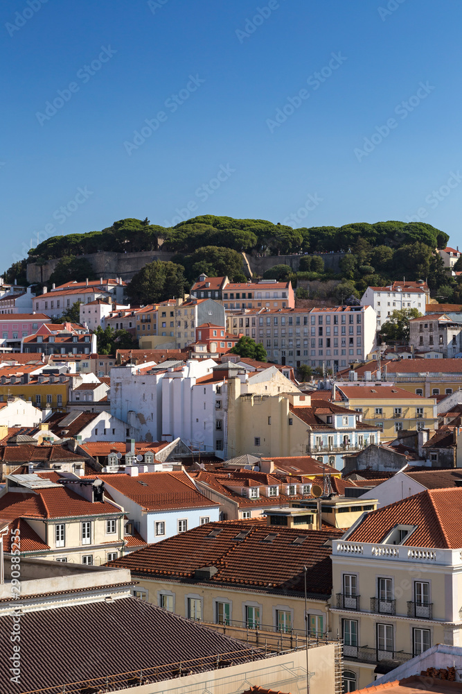 View of Sao Jorge Castle (Saint George Castle, Castelo de Sao Jorge) and old buildings at the historical Alfama district in downtown Lisbon, Portugal, on a sunny day in the summer. Copy space.