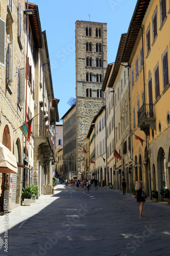 Arezzo  Tuscany  Italy. Street in old town of the medieval city  in background the bell tower of Santa Maria della Pieve also called torre dei cento buchi.