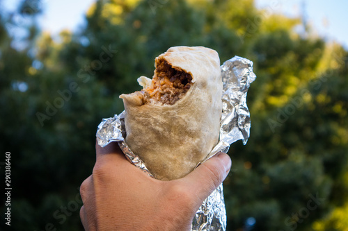 Holding a Burrito with a Bite Out of It in California
