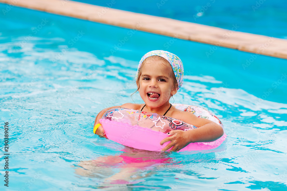 Pretty little girl swimming in outdoor pool