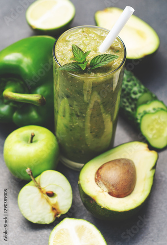Green smoothie of apple, cucumber, avocado and pepper in a glass