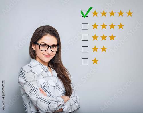 The best rating, evaluation. Business confident happy woman voting to five yellow star to increase ranking. On grey background. Closeup