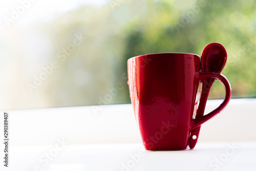 Close-up of red ceramic cup and spoon.