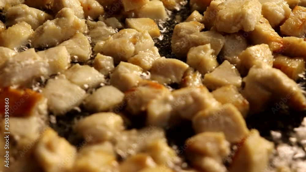 Ruddy pieces of chicken with a yellow crust are fried in a frying pan in a bubbly vegetable oil. Ruddy pieces of chicken with a yellow crust are fried in a frying pan in a bubbly vegetable oil.