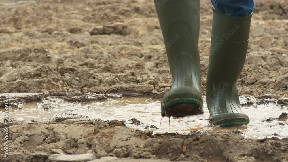 Slow motion low angle, boots walk through mud and dirt Slow motion low angle, boots walk through mud and dirt