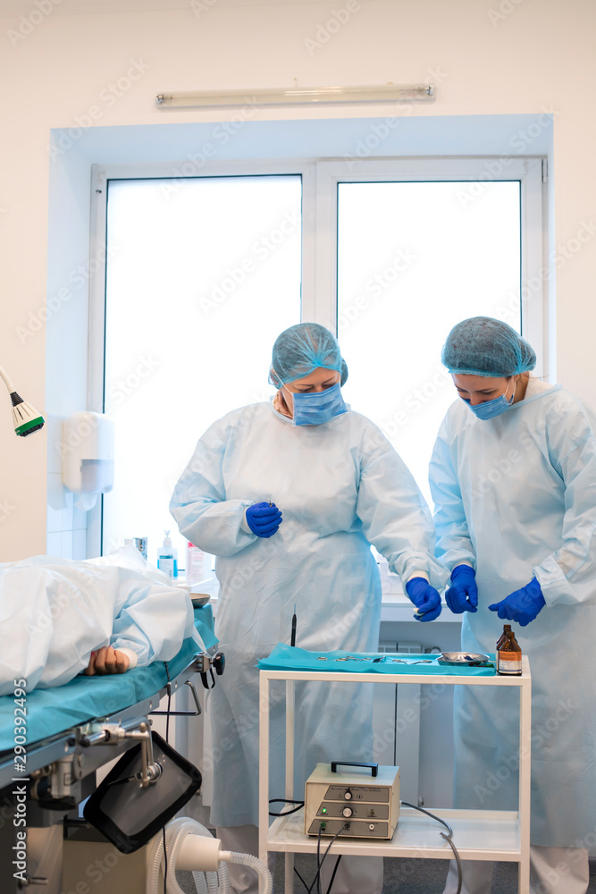 The surgeon takes the instrument from the table. Surgery to remove moles in a private clinic The surgeon takes the instrument from the table. Surgery to remove moles in a private clinic