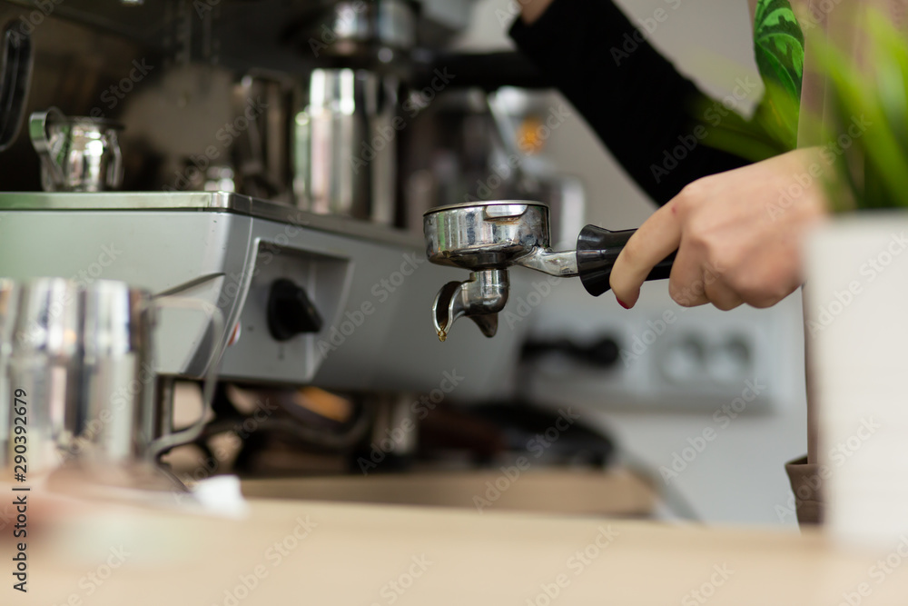 Barista girl is preparing aromatic coffee with a coffee machine. Barista work in a coffee shop Barista girl is preparing aromatic coffee with a coffee machine. Barista work in a coffee shop