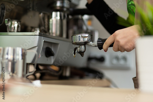 Barista girl is preparing aromatic coffee with a coffee machine. Barista work in a coffee shop