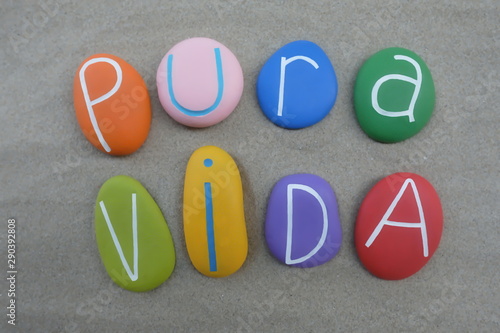 Pura Vida, spanish word used in Costa Rica as a greeting and as a farewell, composed with colored and carved stones over brown sand