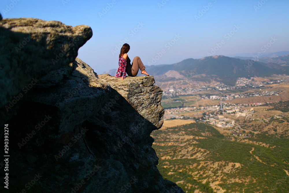 Girl sitting on the edge of a cliff cliff mountain
