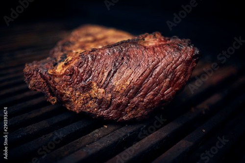 Grilled meats over the barbecue fire. You can see the smoke, the fire and the heat as well as the fiery ones of the melted fats when falling under the direct fire