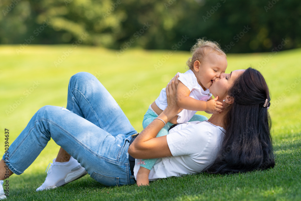 Fototapeta premium Loving young mother kissing her infant daughter