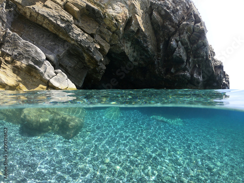 Above and below underwater photo of crystal clear sea paradise rocky seascape full of caves beach of Mouros, Amorgos island, Cyclades, Greece