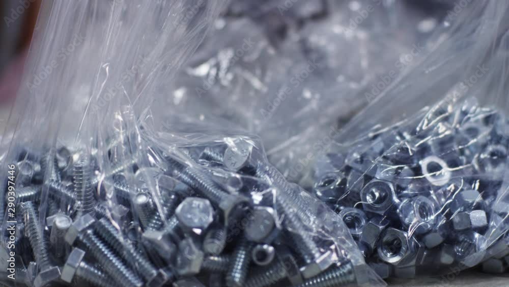 Slow motion close up, nuts and bolts hardware in plastic bags Slow motion close up, nuts and bolts hardware in plastic bags