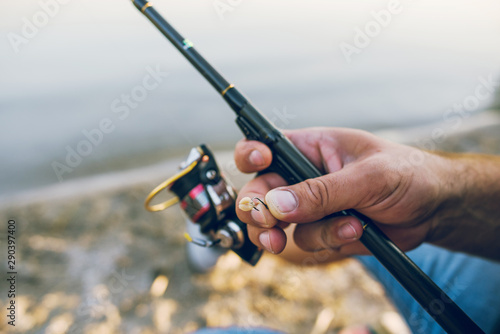 man holding fishing rod in his hand. fishing worms for fishing hooks