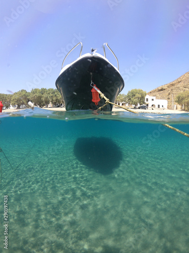 Above and below underwater photo of colourful traditional fishing boat in crystal clear turquoise sea of Astypalaia island, Dodecanese, Greece photo