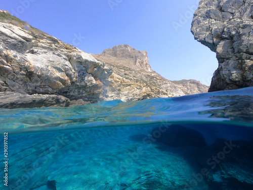 Above and below underwater photo of crystal clear sea paradise rocky seascape and small chapel of Agia Anna just next to iconic Hozoviotissa Monastery  Amorgos island  Cyclades  Greece