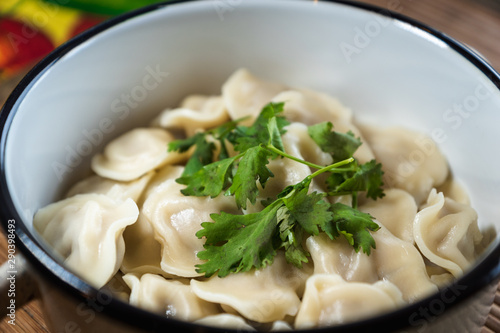 Pelmeni, traditional Russian dumpling dish with meat on table - selective focus, top down photo 