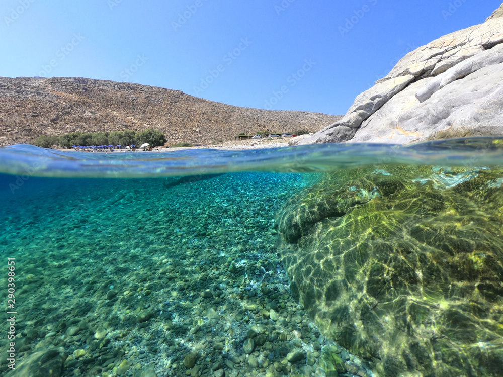 Above and below underwater photo of crystal clear sea paradise rocky seascape of Laki beach in Kato Koufonisi island, Cyclades, Greece