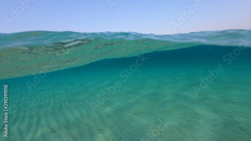 Fototapeta Naklejka Na Ścianę i Meble -  Above and below underwater photo of crystal clear sea paradise rocky seascape of Laki beach in Kato Koufonisi island, Cyclades, Greece