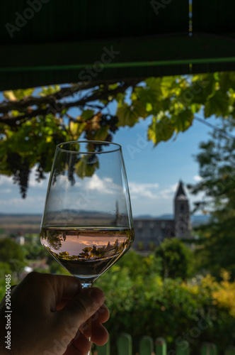 Tasting a glass of rose wine in Zsambek Hungar which is part of the Etyek Wine Region. In the background there is the old monastery church ruin.