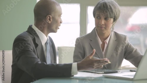 Wallpaper Mural Businessman and businesswoman talking at table with laptop Torontodigital.ca