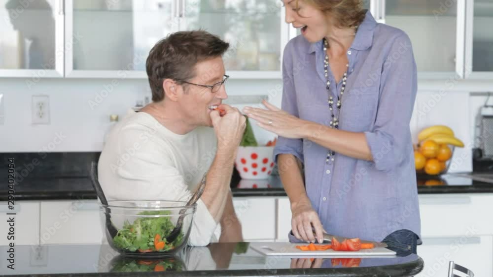 Caucasian couple preparing salad in kitchen Caucasian couple preparing salad in kitchen