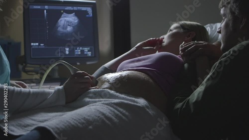 Pregnant Caucasian couple watching ultrasound