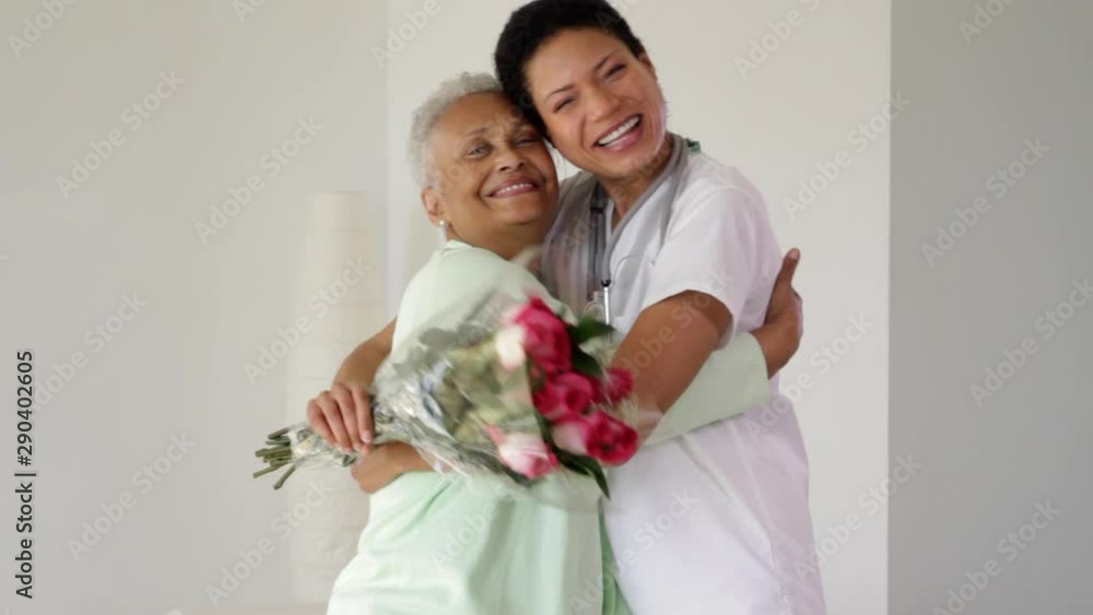 Close up of nurse bringing senior woman flowers Close up of nurse bringing senior woman flowers